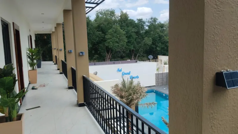 Upper-floor corridor looking down over the swimming pool at Sai Grand Resorts, Kumbakarai